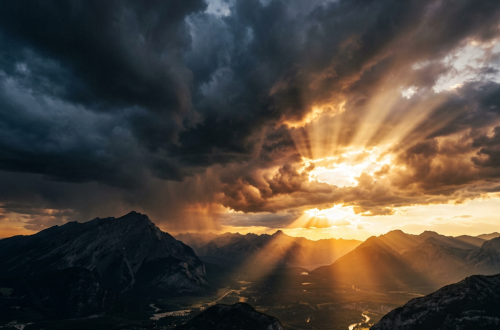Sunset rays piercing through dark storm clouds over a mountainous valley with a river